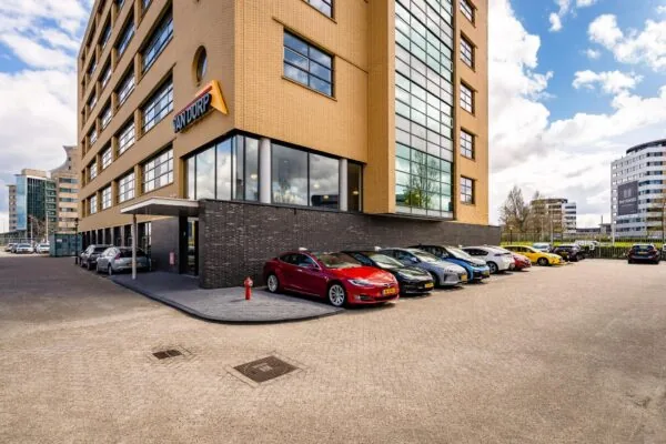 Kantoorgebouw van Van Dorp aan de Fascinatio Boulevard met geparkeerde auto's op de voorgrond.